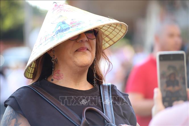 Một phụ nữ Nam Phi thích thú chụp ảnh với nón lá Việt Nam. Ảnh: Hồng Minh - phóng viên TTXVN tại Pretoria, Nam Phi