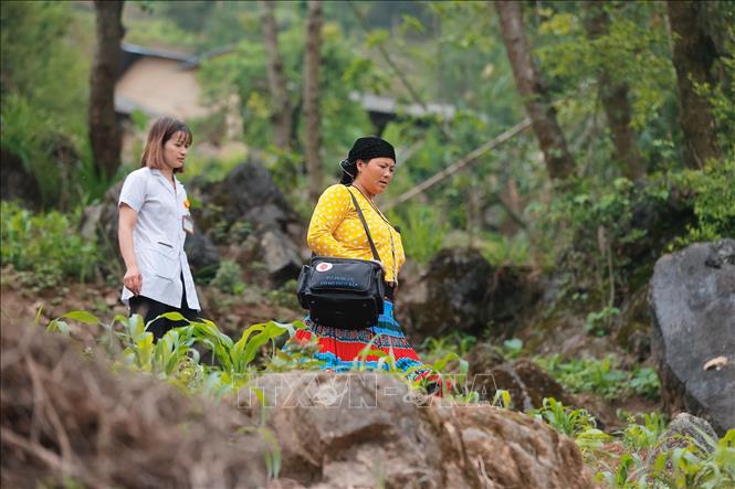 A midwife takes on the hard work of going to remote areas with rough terrain to aid pregnant women. VNA Photo: Minh Quyết