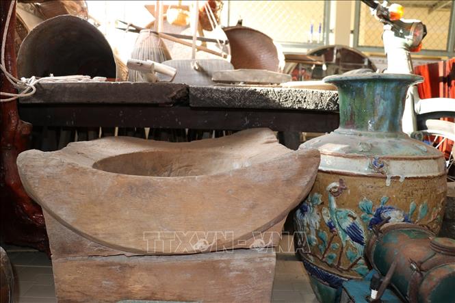 Ché đựng nước (phải) có từ trước năm 1930, được giữ gìn tại nhà ông Hiệu. Ảnh: Hữu Chí - TTXVN