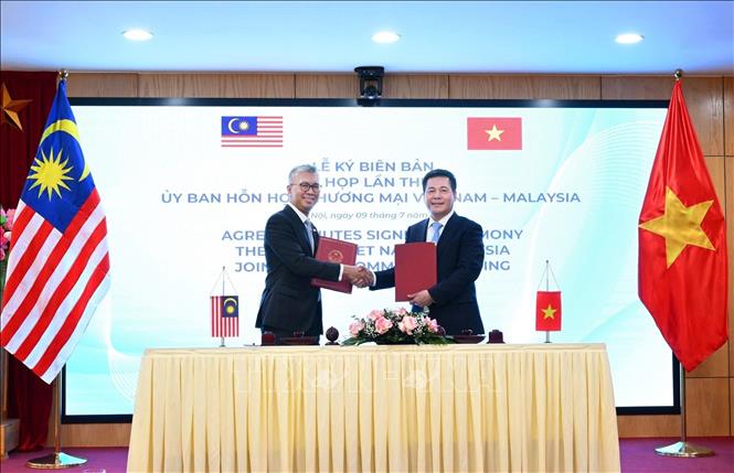 Vietnamese Minister of Trade and Industry Nguyen Hong Dien and Malaysian Minister of Investment, Trade and Industry Zafrul Abdul Aziz exchange the meeting’s documents. VNA Photo: Trần Việt