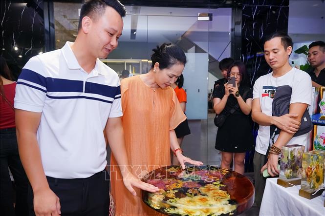 Other than making lights, artisan Thu Hien also creates other products such as tea table from clear resin and dried flowers. VNA Photo 