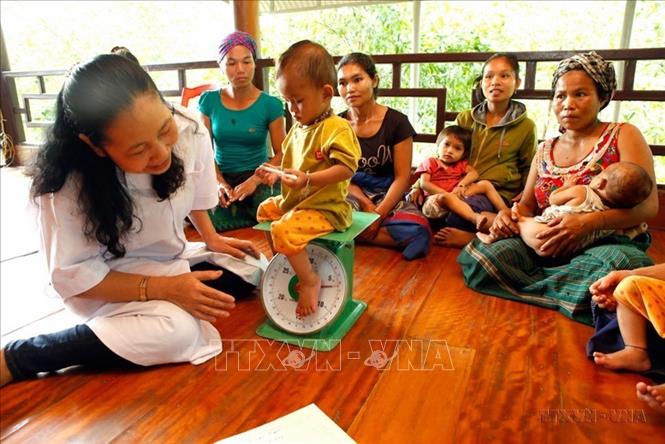 Chất lượng dân số Việt Nam được cải thiện về nhiều mặt. Tình trạng suy dinh dưỡng, tử vong bà mẹ, trẻ em giảm mạnh. Trong ảnh: Nhân viên y tế kiểm tra sức khỏe và tư vấn dinh dưỡng trẻ em cho đồng bào dân tộc xã Trọng Hóa, huyện miền núi Minh Hóa (Quảng Bình). Ảnh: Dương Ngọc – TTXVN