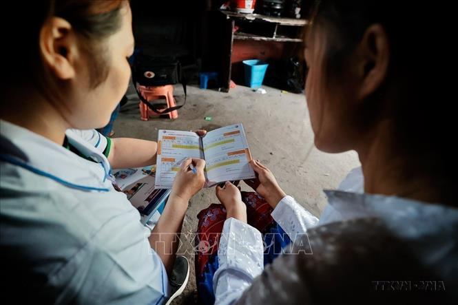 Tình trạng suy dinh dưỡng, tử vong bà mẹ, trẻ em giảm mạnh, tầm vóc, thể lực người Việt Nam có bước cải thiện. Trong ảnh: Nữ hộ sinh Lầu Thị Máy đến phát sổ theo dõi sức khỏe bà mẹ và trẻ em cho phụ nữ mang thai tại thôn Tía Chí Đơ (Hà Giang). Ảnh: Minh Quyết – TTXVN