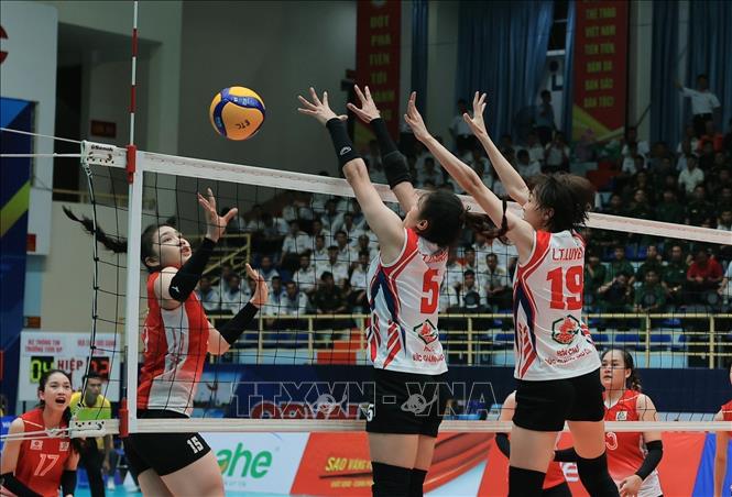Pha tấn công trên lưới của cầu thủ đội Binh chủng Thông tin - Trường Tươi Bình Phước (áo đỏ) bị hai cầu thủ đội Hóa Chất Đức Giang - Lào Cao chắn bóng. Ảnh: Trần Lê Lâm - TTXVN