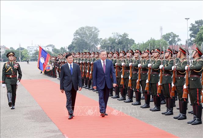 General Secretary of the Lao People's Revolutionary Party (LPRP) Central Committee and President of Laos Thongloun Sisoulith and President To Lam review the guard of honour at the welcome ceremony. VNA Photo: Nhan Sáng