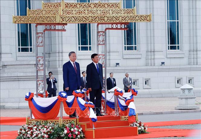 President of Laos Thongloun Sisoulith and President of Vietnam To Lam listen to the two nations' national anthems at the ceremony. VNA Photo: Nhan Sáng