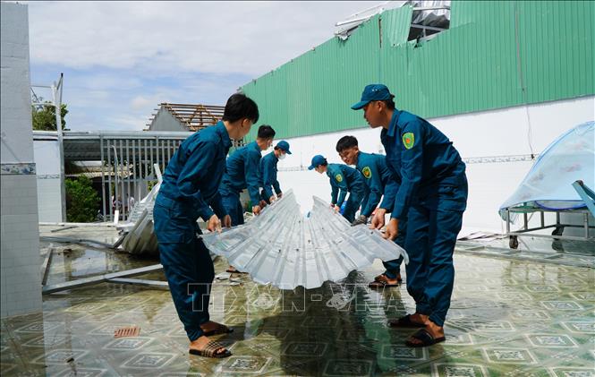 Lực lượng Dân quân giúp người dân khắc phục hậu quả sau giông lốc. Ảnh: Nhựt An - TTXVN