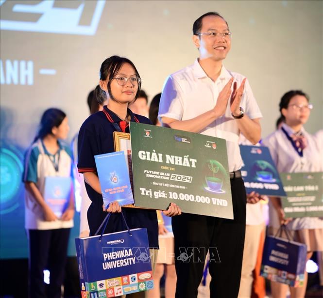 TS. Nguyễn Tiến Hưng - Phó Bí thư Thành đoàn Hà Nội, Chủ tịch Hội Sinh viên Việt Nam thành phố Hà Nội trao giải Nhất cho Đội thi Greener (Trường THPT Trung Giã, Sóc Sơn) với Dự án ECO STRAWS. Ảnh: Minh Đức - TTXVN
