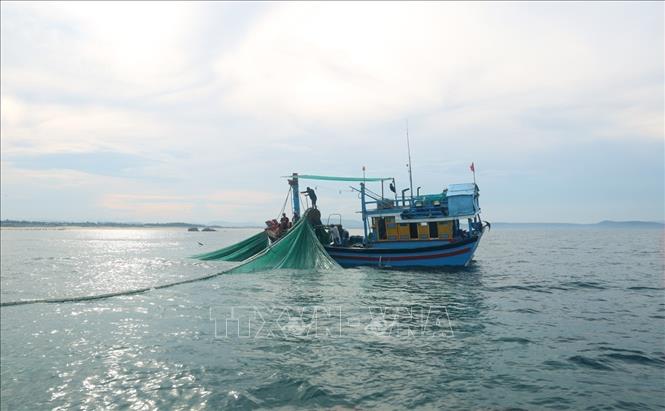 Fishermen draw their nets at dusk with silvery sparkling sun rays on the ocean surface. VNA Photo: Xuân Triệu