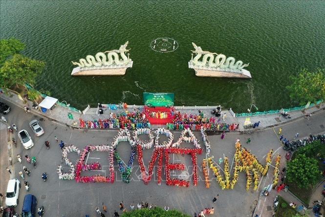 1000 phụ nữ trong trang phục áo dài truyền thống xếp chữ nhân ngày xác lập kỷ lục. Ảnh: TTXVN