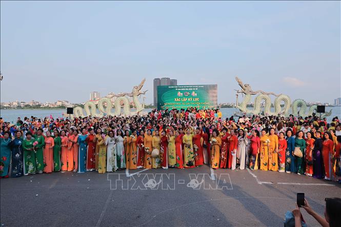 1000 phụ nữ trong tà áo dài truyền thống có hoạ tiết hoa sen tham dự chương trình để xác lập kỷ lục. Ảnh: Hoàng Hiếu - TTXVN