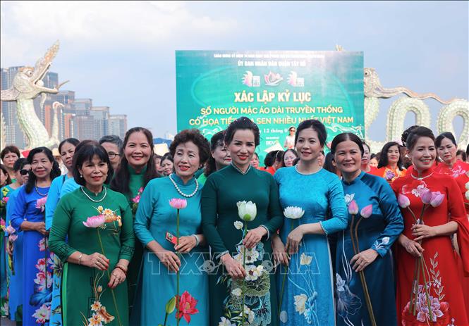 Áo dài đủ màu sắc, kiểu dáng với hoạ tiết sen được trình diễn tại chương trình. Ảnh: Hoàng Hiếu - TTXVN