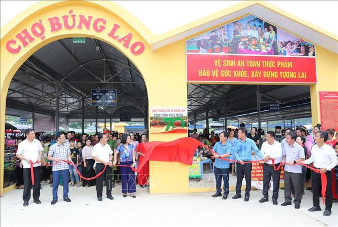 Đại biểu thực hiện nghi thức gắn biển Chợ trung tâm xã Búng Lao. Ảnh: Xuân Tư - TTXVN