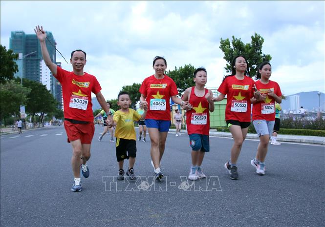 Một gia đình cùng tham gia Giải chạy VnExpress Marathon Da Nang Midnight 2024. Ảnh: Trần Lê Lâm - TTXVN 
