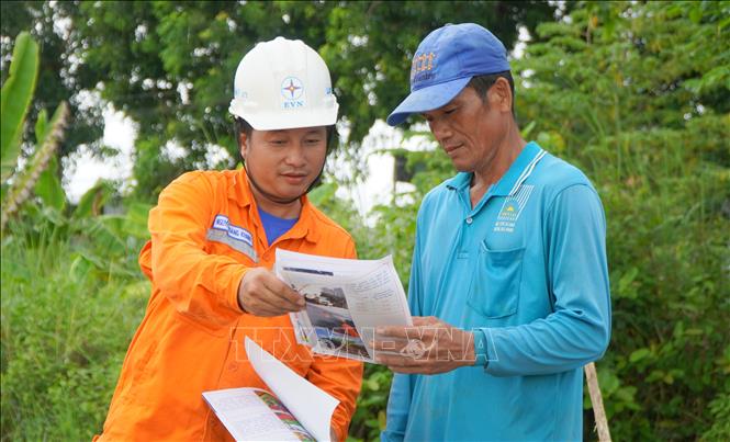 Nhân viên điện lực huyện Thanh Bình tuyên truyền, hướng dẫn người dân cách sử dụng điện an toàn. Ảnh: Nhựt An - TTXVN