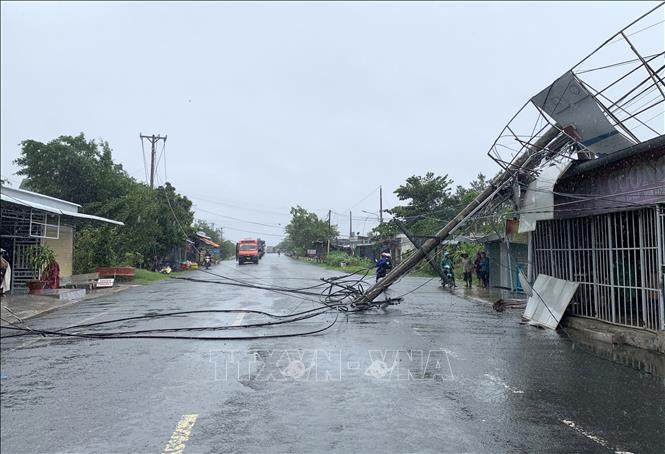 Trận dông lốc quét qua xã Phong Hòa, huyện Lai Vung ngày 11/7/2024 làm gãy 2 trụ điện, ngã ra Quốc lộ 54 gây mất điện cục bộ. Ảnh: TTXVN phát