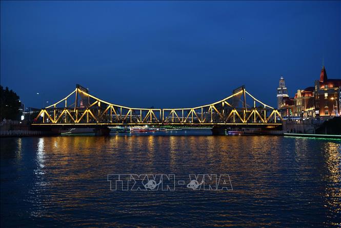 Khi thành phố lên đèn cũng là lúc dòng sông Hải Hà lấp lánh bừng sáng bởi hệ thống ánh sáng khổng lồ từ hàng loạt cây cầu độc đáo và những tòa nhà với đủ loại hình kiến trúc dọc hai bờ sông, tạo ra một bức tranh đầy màu sắc. Ảnh: Công Tuyên-P/v TTXVN tại Trung Quốc