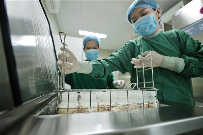 Nhân viên y tế cho sữa vào thanh trùng trước khi được chuyển tới các khoa cho bệnh nhi. Ảnh: Minh Quyết - TTXVN