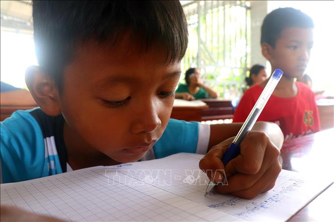 Học sinh học viết chữ Khmer tại lớp dạy chữ Khmer ấp Thới Trường 1, xã Thới Xuân. Ảnh: Thu Hiền - TTXVN