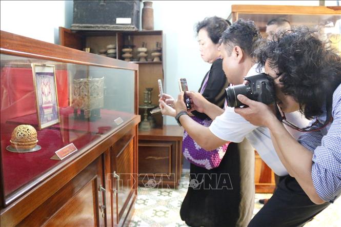 Du khách chụp ảnh bộ vương miện của Vua Pô Klong Mơh Nai và búi tóc của Hoàng hậu Po Bia Som bằng chất liệu vàng với đường nét chạm khắc hoa văn tinh xảo, độc đáo đầu thế kỷ XVII.
Ảnh: Nguyễn Thanh - TTXVN