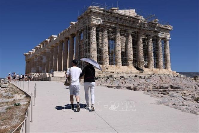 Du khách che ô tránh nắng nóng khi tham quan thành cổ Acropolis ở Athens, Hy Lạp, ngày 16/7/2024. Ảnh: Getty Images/ TTXVN