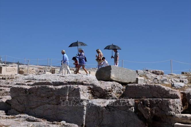 Du khách che ô tránh nắng nóng khi tham quan thành cổ Acropolis ở Athens, Hy Lạp, ngày 16/7/2024. Ảnh: Getty Images/ TTXVN