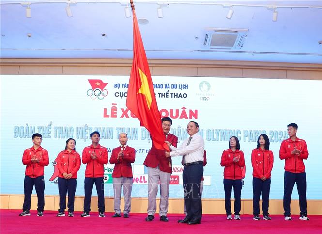 Minister of Culture, Sports and Tourism Nguyen Van Hung, who is President of Vietnam Olympic Committee, hands over the Olympic flag to the Vietnamese sporting delegation. VNA Photo: Minh Quyết 