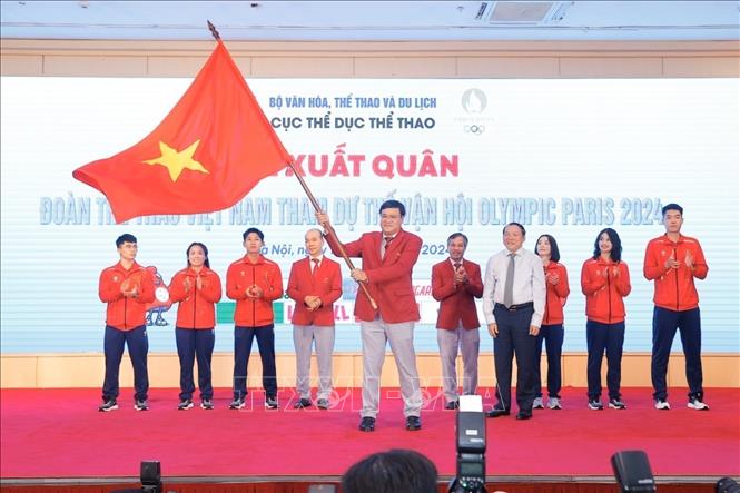 Minister of Culture, Sports and Tourism Nguyen Van Hung, who is President of Vietnam Olympic Committee, hands over the Olympic flag to the Vietnamese sporting delegation. VNA Photo: Minh Quyết