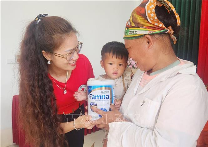 Chủ tịch Hội Chữ thập đỏ tỉnh Lạng Sơn Nông Bích Thuận trao sữa cho trẻ em nghèo, khuyết tật, có hoàn cảnh khó khăn huyện Đình Lập tại Chương trình. Ảnh: Anh Tuấn – TTXVN