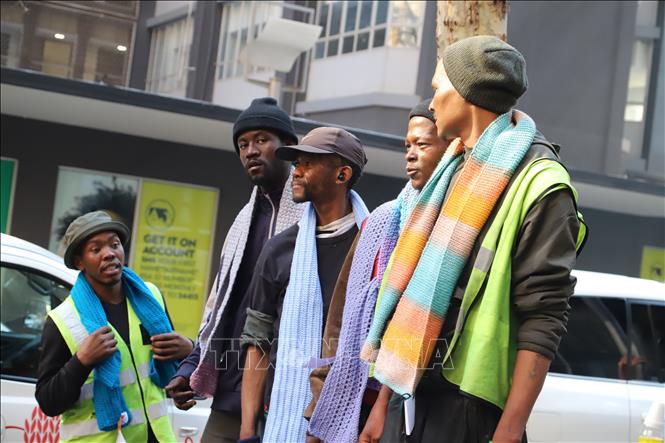 Những công nhân trên đường phố Johannesburg được tặng những chiếc khăn ấm của tổ chức Blankets for Nelson Mandela Day. Ảnh: Hồng Minh - PV TTXVN tại Nam Phi