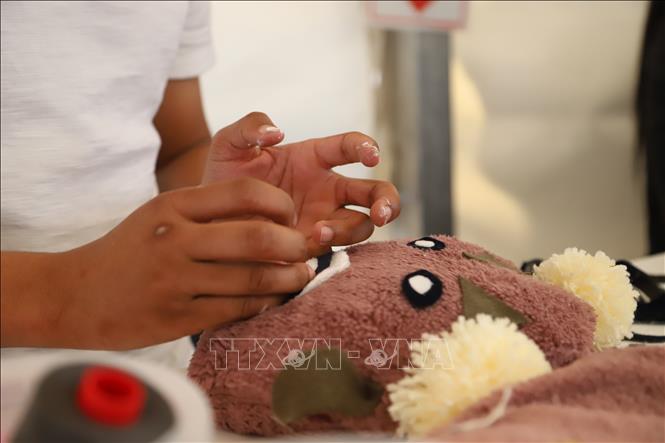 Một tình nguyện viên nắn nót làm đồ chơi để tặng cho trẻ em khó khăn tại sự kiện của tổ chức Ladles of Love (Những muỗng thức ăn nghĩa tình). Ảnh: Hồng Minh - PV TTXVN tại Nam Phi