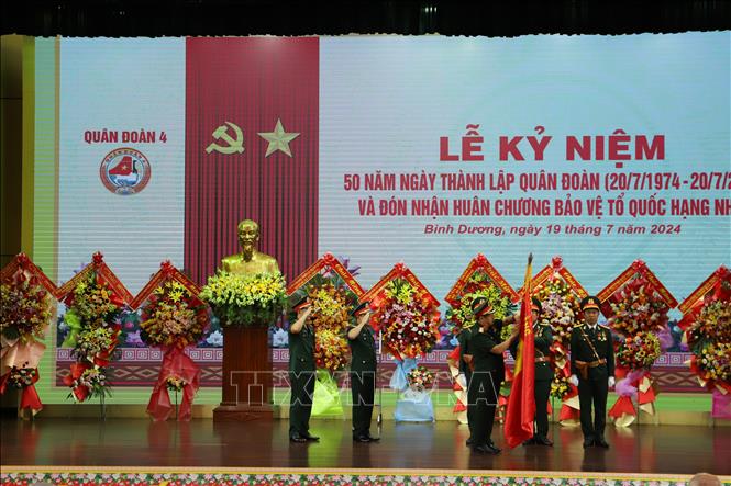Thừa ủy quyền của Chủ tịch nước, Thượng tướng Phạm Hoài Nam gắn Huân chương bảo vệ Tổ quốc hạng Nhất lên Quân kỳ quyết thắng của Quân đoàn 4. Ảnh: Huyền Trang - TTXVN