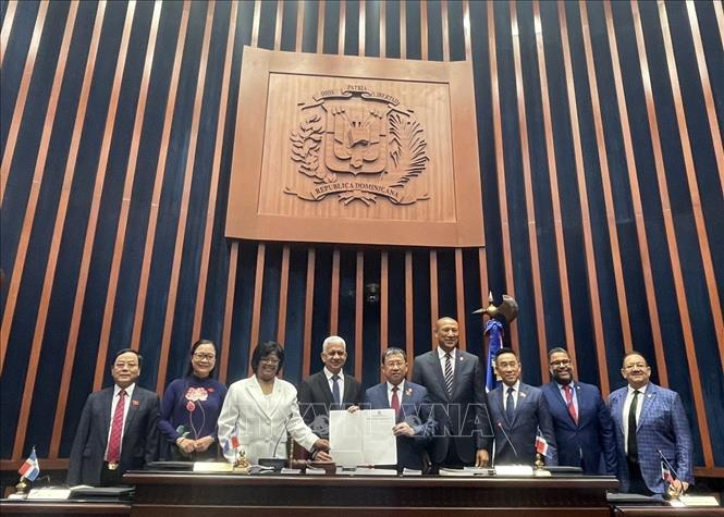 President of the Senate of the Dominican Republic Ricardo de los Santos presents the Resolution to establish the Dominican - Vietnam Parliamentary Friendship Group to Chairman of the NA’s Committee for External Relations Vu Hai Ha. VNA Photo