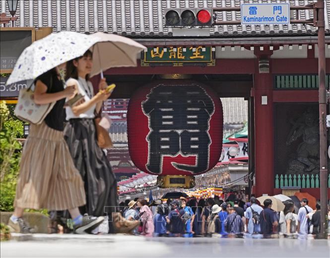 Người dân che ô tránh nắng nóng tại Tokyo, Nhật Bản, ngày 18/7/2024. Ảnh: Kyodo/TTXVN