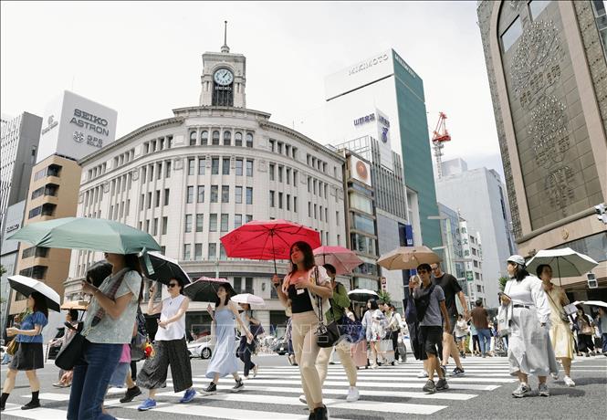 Người dân che ô tránh nắng nóng tại Tokyo, Nhật Bản, ngày 18/7/2024. Ảnh: Kyodo/TTXVN