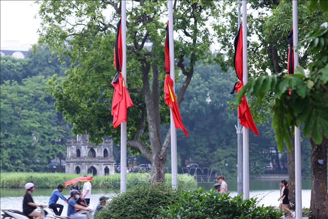 Cờ rủ treo tại khuôn viên vườn hoa Lý Thái Tổ, tưởng nhớ Tổng Bí thư Nguyễn Phú Trọng. Ảnh: Văn Điệp – TTXVN
