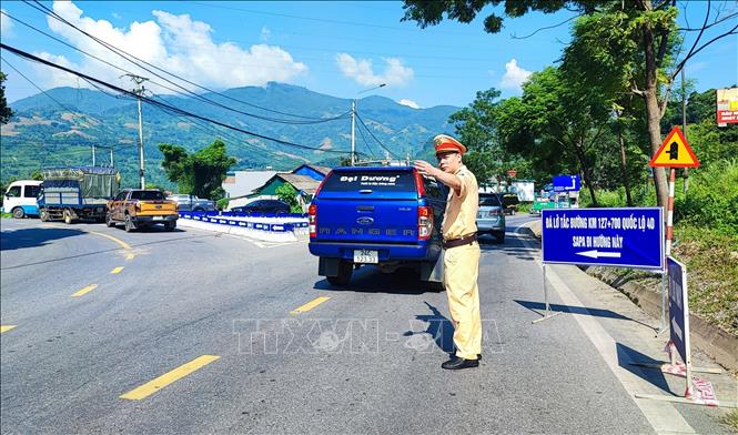 Lực lượng chức năng tổ chức phân luồng cho các phương tiện tham gia giao thông. Ảnh: Quốc Khánh - TTXVN