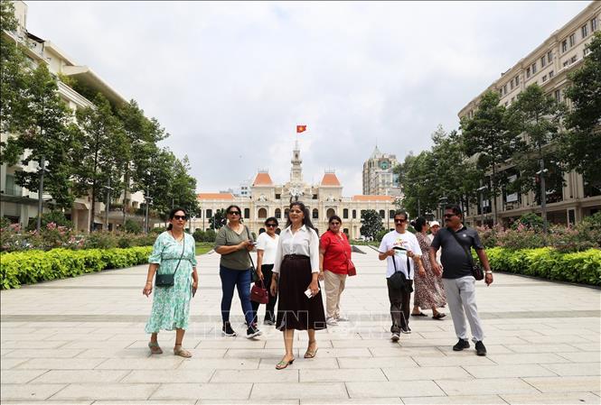 Tourists walk on Nguyen Hue Walking street and visit the edifice of the Ho Chi Minh city’s People’s Committee. VNA Photo: Hồng Đạt