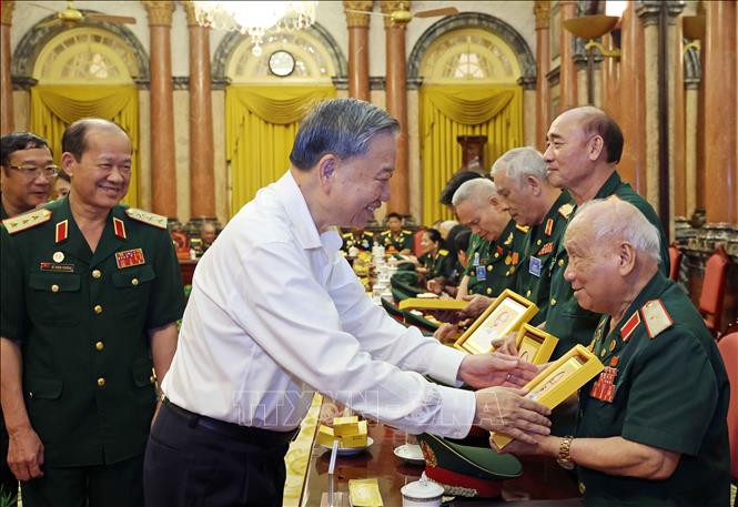 Chủ tịch nước Tô Lâm tặng ảnh Chủ tịch Hồ Chí Minh cho Thiếu tướng Võ Sở, 96 tuổi, Trưởng ban Ban Liên lạc truyền thống cựu chiến binh Đại đoàn 305 Dù - Đặc công phát biểu. Ảnh: Nhan Sáng-TTXVN