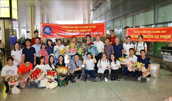 Các thầy cô, học sinh trường THPT chuyên (trường đại học Sư Phạm Hà Nội) đón và chúc mừng Trần Duy cùng Tạ Đức Anh. Ảnh: Thanh Tùng - TTXVN