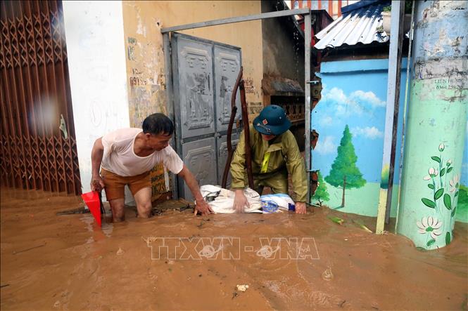 Nhân dân phường Quyết Thắng, thành phố Sơn La che chắn để hạn chế nước chảy vào nhà. Ảnh: Quang Quyết - TTXVN 