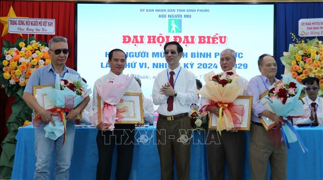 Chủ tịch Hội Người mù Việt Nam Phạm Viết Thu tặng Kỷ niệm chương Vì hạnh phúc người mù cho các cá nhân. Ảnh: Nhật Bình - TTXVN