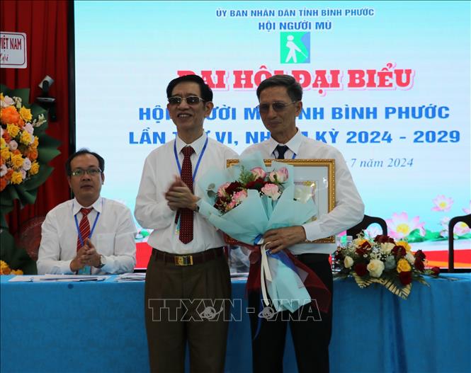 Chủ tịch Hội Người mù Việt Nam Phạm Viết Thu tặng Bằng khen cho cho tập thể Hội người mù tỉnh Bình Phước. Ảnh: Nhật Bình - TTXVN
