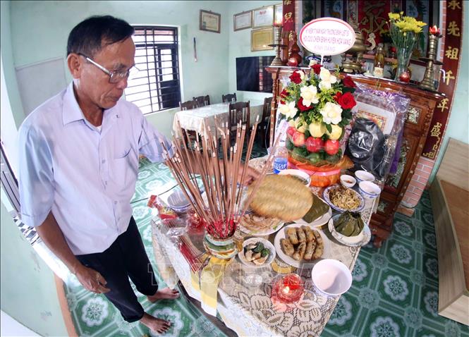 Ông Nguyễn Quang Vinh bên mân cúng giỗ tri ân các Anh hùng Liệt sĩ. Ảnh: Trần Lê Lâm - TTXVN