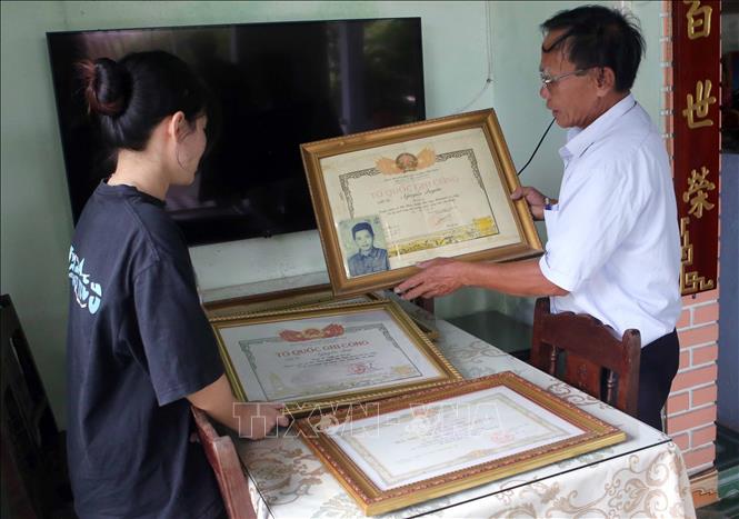 Ông Nguyễn Quang Vinh đang kể về các chiến công của 3 Liệt sĩ và 2 mẹ Việt Nam Anh hùng với các bạn trẻ. Ảnh: Trần Lê Lâm - TTXVN