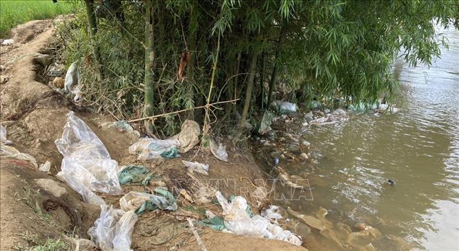 Những bao nilon bọc thuốc lá trôi dọc bờ sông Quây Sơn ra cột mốc biên giới. Ảnh: TTXVN phát