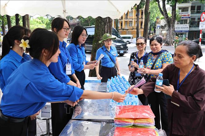 Các tình nguyện viên Thủ đô phục vụ miễn phí nước uống, đồ ăn nhẹ, quạt giấy cho người dân đến viếng và tiễn đưa Tổng Bí thư Nguyễn Phú Trọng. Ảnh: Minh Đức – TTXVN