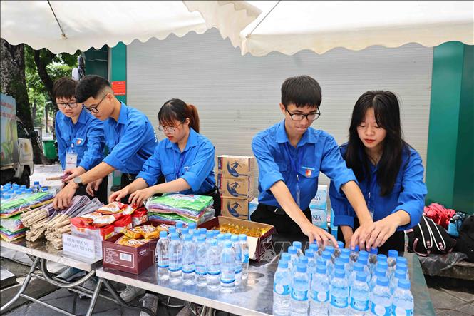 Tại các chốt trực, Thành đoàn đều bố trí điểm phục vụ miễn phí, cung cấp nước uống, đồ ăn nhẹ, quạt giấy, ô dù, áo mưa… cho người dân đến tiễn đưa Tổng Bí thư Nguyễn Phú Trọng. Ảnh: Minh Đức – TTXVN