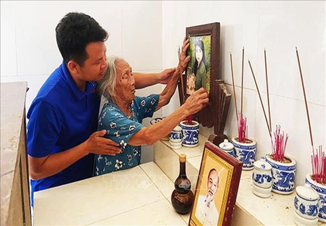 Trao tặng di ảnh liệt sĩ Nguyễn Thị Đầm, con của Mẹ Việt Nam Anh hùng Phạm Thị Hư (92 tuổi, ở xã Quảng Thái, huyện Quảng Điền). Ảnh: TTXVN phát