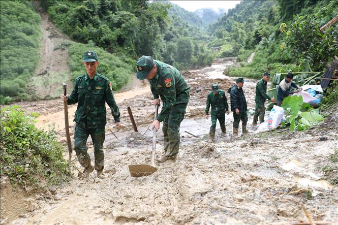 Bộ đội Biên phòng tỉnh Điện Biên giúp dân dọn dẹp vệ sinh môi trường sau lũ quét. Ảnh: Phan Quân - TTXVN